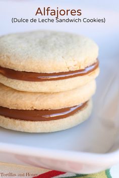 three cookies are stacked on top of each other in a white plate with chocolate drizzle