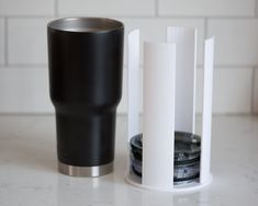 a black and white tumbler next to a stack of cookies