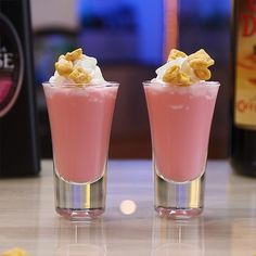 two glasses filled with food sitting on top of a table