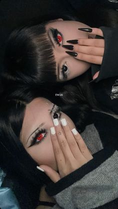 two women with black and white nail polishes on their faces, one holding her hands to her face