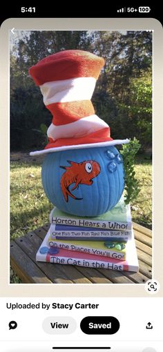 the cat in the hat is stacked on top of books and has an orange fish