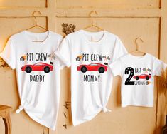 two t - shirts with the words pit crew and mommy on them hanging from a wall