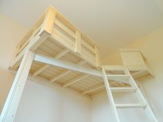 there is a loft bed with a ladder on the top and a light above it