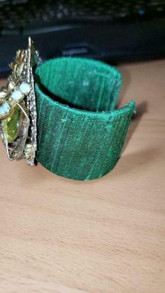 A GORGEOUS COMPOSITE OF MANY VINTAGE JEWELRY ADHERED TO A GREEN SILK CUFF. THE CUFF IS MALLEABLE AND CAN BE ADJUSTED AFTER PURCHASE. THIS IS A OOAK CREATION, HEFTY 2.9 OUNCES-More Treasures Here- https://www.etsy.com/shop/TreasureFoundToShare Unique Brooch, Mothers Day Special, Green Silk, Vintage Jewels, How To Make Earrings, Green And Gold, Cuff Bracelet, Cuff Bracelets, Vintage Jewelry