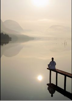 a person sitting on a dock looking out at the water