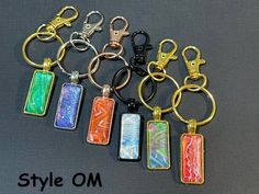 six keychains with different designs on them and the words style om written in gold