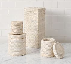 three woven storage containers sitting on top of a white counter