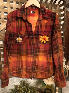 This one-of-a-kind women's flannel is handmade and is perfect for any occasion, whether it's a casual day out or a fancy cocktail party. The shirt features a brown/orange check pattern with a collared neckline and button closure. The long-sleeved shirt is made of 100% cotton flannel material with, stitched on real wool flower  patches embellishments and button accents, making it an excellent choice for bohemian-themed events. It comes with a Fall  Iron on Decal on the back! the pockets are made from 100%wool embellishments I hand designed women's Medium! Blousy! Know two are the same, I use new or like new flannels and distress them and create unique pieces! Comes with a free piece of Plunder Jewelry! Thank you everyone for visiting my store! I have a love for Distressed Boho up-cycled Clo Bohemian Cotton Shirt For Fall, Fall Festival Cotton Shirt, Cotton Festival Shirt For Fall, Handmade Casual Fall Tops, Fancy Cocktail Party, Orange Flannel, Cocktail Chic, Plunder Jewelry, Flannel Women