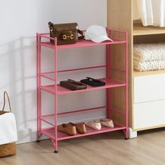 a pink shelf with shoes and purses on it next to a white bed in a room