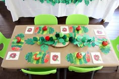 the very hungry caterpillar table is set up with green chairs and place mats