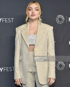 a woman in a beige suit poses on the red carpet at palefest, which is celebrating