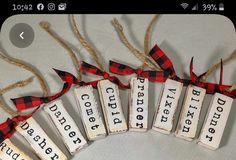 some type of wooden sign hanging from a string with red and black plaid ribbon around it