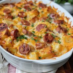 a casserole dish with sausage, potatoes and cheese