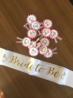 the bride to be sash has been placed on top of a table with pink and white ribbons