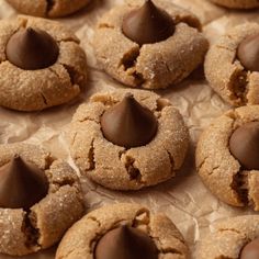 some cookies with chocolate on top are sitting on wax paper and ready to be eaten