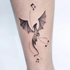 a black and white photo of a dragon with music notes on it's leg