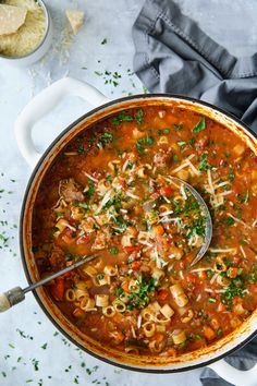 a large pot filled with pasta soup and garnished with parsley