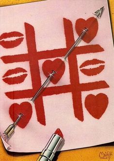 a piece of paper with lipstick drawn on it and some scissors in front of it