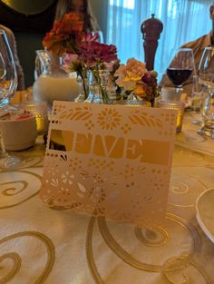 the table is set with flowers and wine glasses