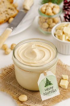 a jar filled with cream sitting on top of a table next to other food items