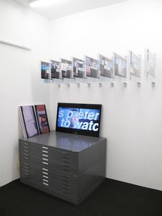 a television sitting on top of a stack of drawers in front of a white wall