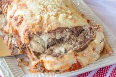 meatloaf stuffed with cheese and sauce on a white plate