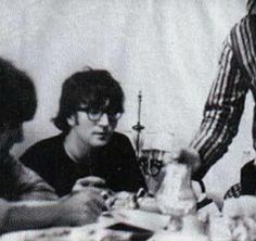 three people sitting at a table with food and drinks