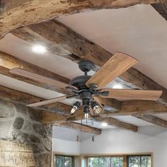 a living room with a ceiling fan and stone fireplace