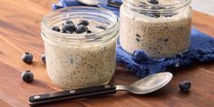 two mason jars filled with blueberries and chia seeds on top of a wooden table