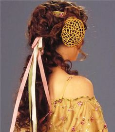 a woman with long hair wearing a yellow dress and a gold brooch on her head