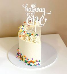 a birthday cake with sprinkles and the word happy to one on top