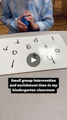 a little boy sitting at a table with a blue ball in front of him and the words, small group interaction and enticment time in my children's classroom