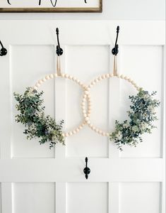 a white door with wreaths hanging on it