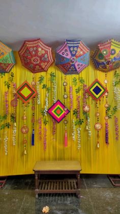 the wall is decorated with colorful umbrellas hanging from it's sides and flowers on them