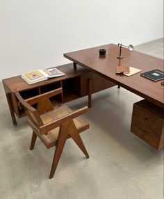 a wooden desk with a chair and book on it