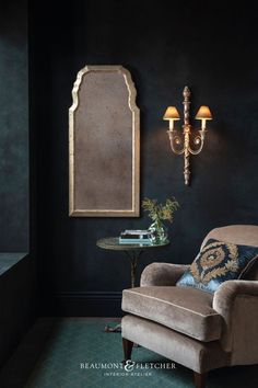 A tall silver mirror with antiqued mirror glass, hanging on dark wall in a classic room setting. Chinoiserie Mirror, Historical Design