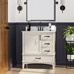 a bathroom vanity with a mirror and potted plant in front of it on the floor