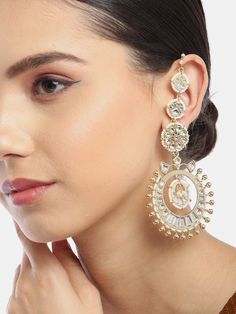 These gorgeous off-white flower-shaped multi-layer earrings come with kundan stone studs & beads, are gold-plated, have an integrated ear chain and secured with a post and back closure. These unique handcrafted jhumkas can be styled with any traditional outfit, or an evening outfit to add that Wow! factor. Product color may vary based on the monitor or screen you are using.See FAQ for more details. Size Length of earring: 8.5 cmLength of ear chain: 13 cm Details Material: BrassStones: Kundan & A Festive Fusion Style White Danglers, Festive White Fusion Danglers, Festive Fusion White Danglers, White Fusion Danglers With Latkans, White Chandbali Earrings With Gota Work, Elegant White Danglers With Gota Work, White Kundan Fusion Bridal Earrings, White Gold Plated Earrings For Diwali, White Drop Earrings For Reception