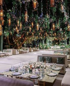 an outdoor dining area with tables, chairs and lights hanging from the ceiling above it