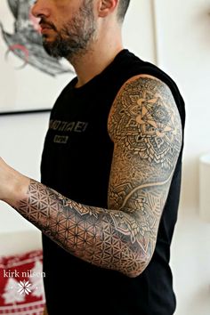 a man with tattoos on his arms and arm is holding a cell phone in his hand