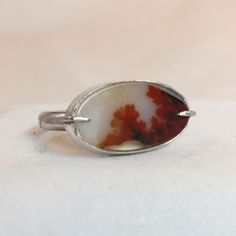 This ring features a natural dendritic agate with magical fern like inclusions. Horizontally set in a fine silver bezel and accented with two prongs (or claws) for a contemporary edge, you will will love this one of a kind ring. Brushed finish and hammered half round band complete the modern look.  Size:           7.5 US Dendritic Agate:   ~ 19 x 10 mm Band:        2.9 mm sterling silver Nature-inspired Agate Rings With Natural Inclusions, Dendritic Quartz, Grey Diamond Ring, Tourmalated Quartz, Claw Ring, Gold And Silver Rings, Dendritic Agate, Grey Diamond, July Birthstone