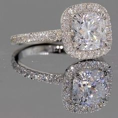 an engagement ring with a cushion cut diamond surrounded by pave diamonds