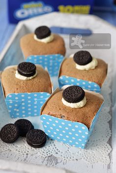 four cupcakes with oreo cookies and cream in them on a blue plate