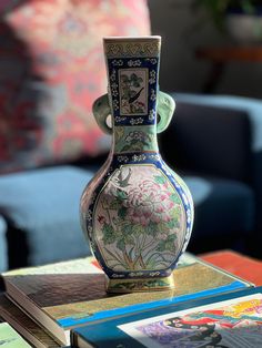 a vase sitting on top of a table in front of a blue chair and couch