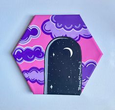 an ornament shaped like a night sky with clouds and a door in the middle