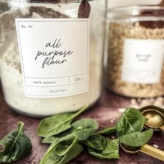 all purpose flour in a glass jar with gold spoons and spinach sprouts