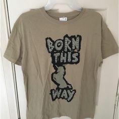 a t - shirt with the words born this way on it hanging from a door