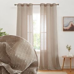 a living room with white walls and curtains