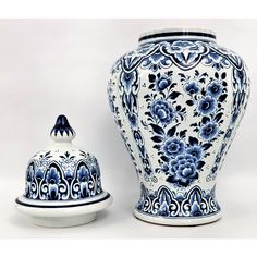 a large blue and white vase next to a small ceramic bowl on a white surface