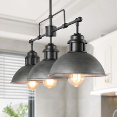 three lights hanging from the ceiling in a kitchen